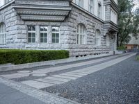 the driveway is lined with small shrubs and brick bricks and cement blocks and bricks that are next to the walkway