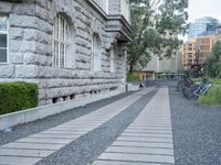 the driveway is lined with small shrubs and brick bricks and cement blocks and bricks that are next to the walkway