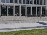 a brick building with glass windows and sidewalk leading to it and a black fire hydrant