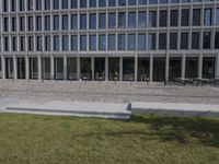 a brick building with glass windows and sidewalk leading to it and a black fire hydrant