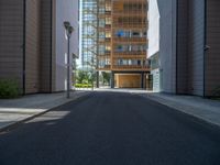 a road through which is a large modern building with an awning over it's entrance