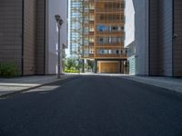 a road through which is a large modern building with an awning over it's entrance