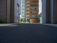 a road through which is a large modern building with an awning over it's entrance