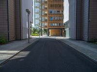 a road through which is a large modern building with an awning over it's entrance