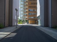 a road through which is a large modern building with an awning over it's entrance