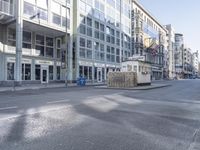 a deserted city street with several tall buildings behind it in a bright day light,