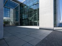 modern commercial building in urban area with large glass windows with a grey cobble floor