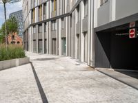 an alley with parking garages and a building in the background that is almost empty