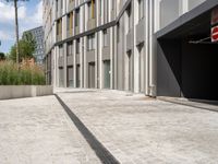 an alley with parking garages and a building in the background that is almost empty