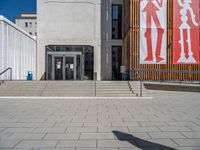 a group of people riding skateboards near wooden panels and stairss with artwork on them