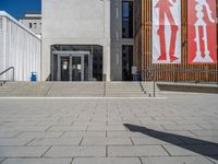 a group of people riding skateboards near wooden panels and stairss with artwork on them