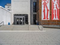 a group of people riding skateboards near wooden panels and stairss with artwork on them