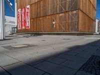 a group of people riding skateboards near wooden panels and stairss with artwork on them