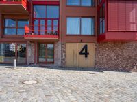 the number 4 is written in front of a brick building and windows at the bottom