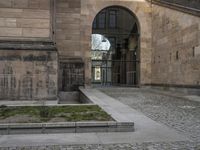 some steps and an umbrella in a large stone building near an open gate and windows