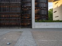 a black skateboard that is leaning against a wall and a red ball on the concrete floor