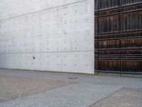 a man is standing next to an open building and holding a skateboard with a ball on it