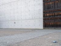 a man is standing next to an open building and holding a skateboard with a ball on it