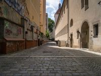 a narrow alley is shown with a few cobblestones in it's center