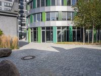 large boulders sit in front of a building with many glass doors and windows on one side