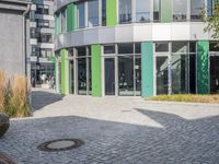 large boulders sit in front of a building with many glass doors and windows on one side