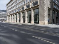 a person walking on an empty street next to some buildings and buildings in the city