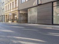 a man riding a motorcycle past a store on a street side walk on a sunny day