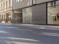 a man riding a motorcycle past a store on a street side walk on a sunny day