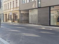 a man riding a motorcycle past a store on a street side walk on a sunny day