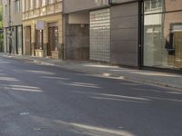 a man riding a motorcycle past a store on a street side walk on a sunny day