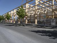 a building being constructed and some trees on the side of the road outside it and the street lights