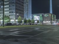 view of a street that has cars parked in front of it at night with lights on