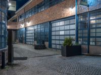 some dark blue windows in an industrial building with no one on the street to the right