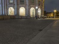 a person is standing on an empty brick walkway by the tv tower and trees with lights