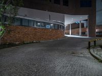 some dark blue windows in an industrial building with no one on the street to the right