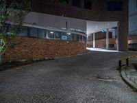 some dark blue windows in an industrial building with no one on the street to the right