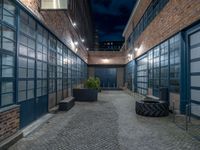 some dark blue windows in an industrial building with no one on the street to the right