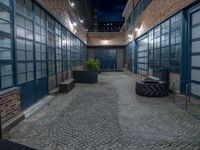 some dark blue windows in an industrial building with no one on the street to the right