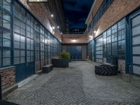 some dark blue windows in an industrial building with no one on the street to the right