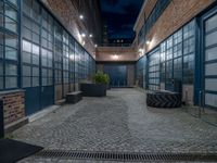 some dark blue windows in an industrial building with no one on the street to the right