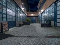 some dark blue windows in an industrial building with no one on the street to the right