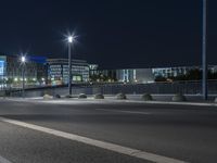 large building on the street with lights in front and other buildings nearby at night with no one moving