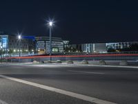 large building on the street with lights in front and other buildings nearby at night with no one moving