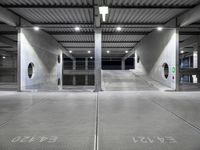 a garage with an empty parking lot filled with metal equipment and signs at night time