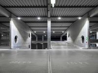 a garage with an empty parking lot filled with metal equipment and signs at night time