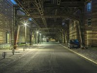 a deserted road with streetlights on it at night in the city or town,