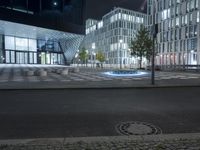 a street corner near a building at night with people walking by the walkway and steps