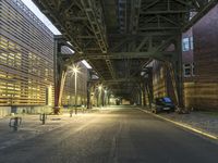 the streets and bridges of an empty alley in a city at night time lit up by street lights