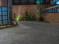 some dark blue windows in an industrial building with no one on the street to the right