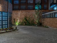 some dark blue windows in an industrial building with no one on the street to the right